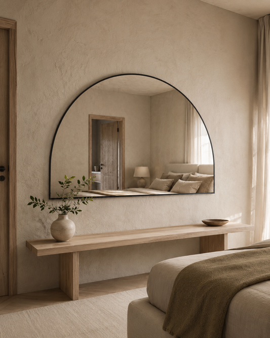 Danielle D-shape wall mirror in Matte Black, styled above a bench in a bedroom