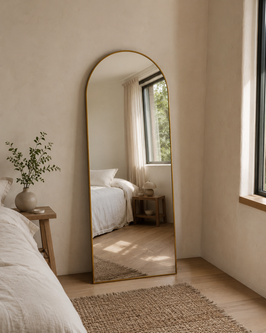 Sienna Copper LED arch mirror in Antique Copper, styled in a bedroom