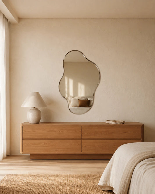 Luisa puddle wall mirror above a low oak dresser in a bedroom
