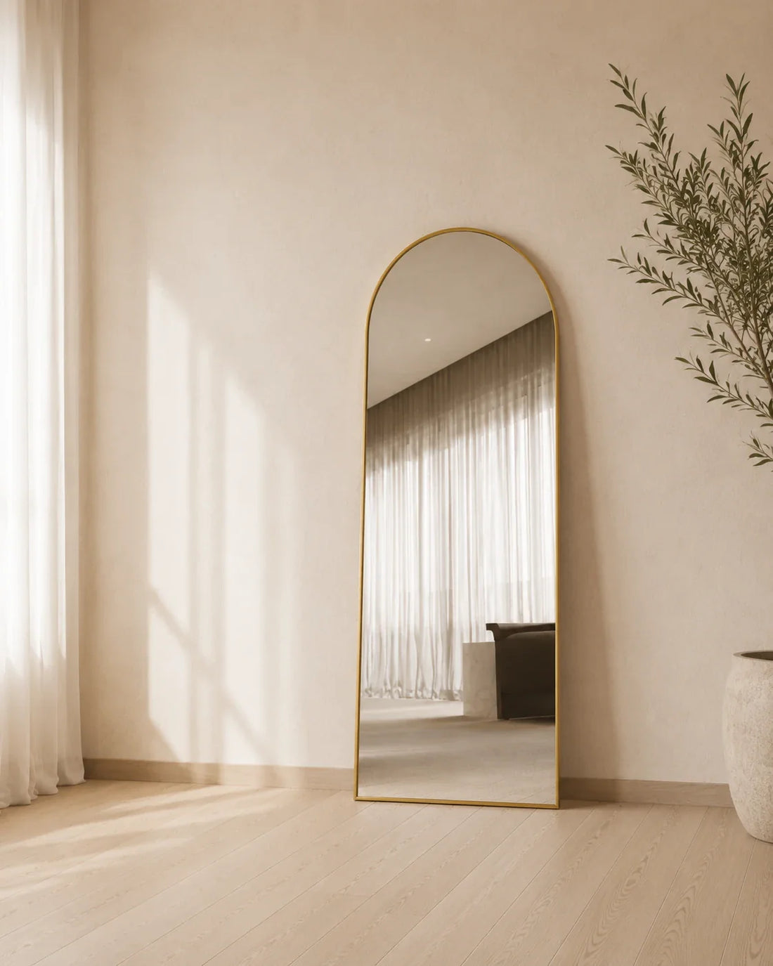 Sienna arch full length mirror leaning against a curtained living room wall