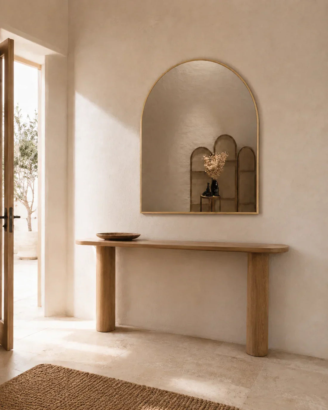 Vittoria arch wall mirror mounted above a timber console table in an entryway
