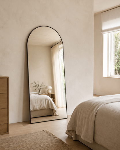 Sienna arch full length mirror in Matte Black, styled leaning in a bedroom