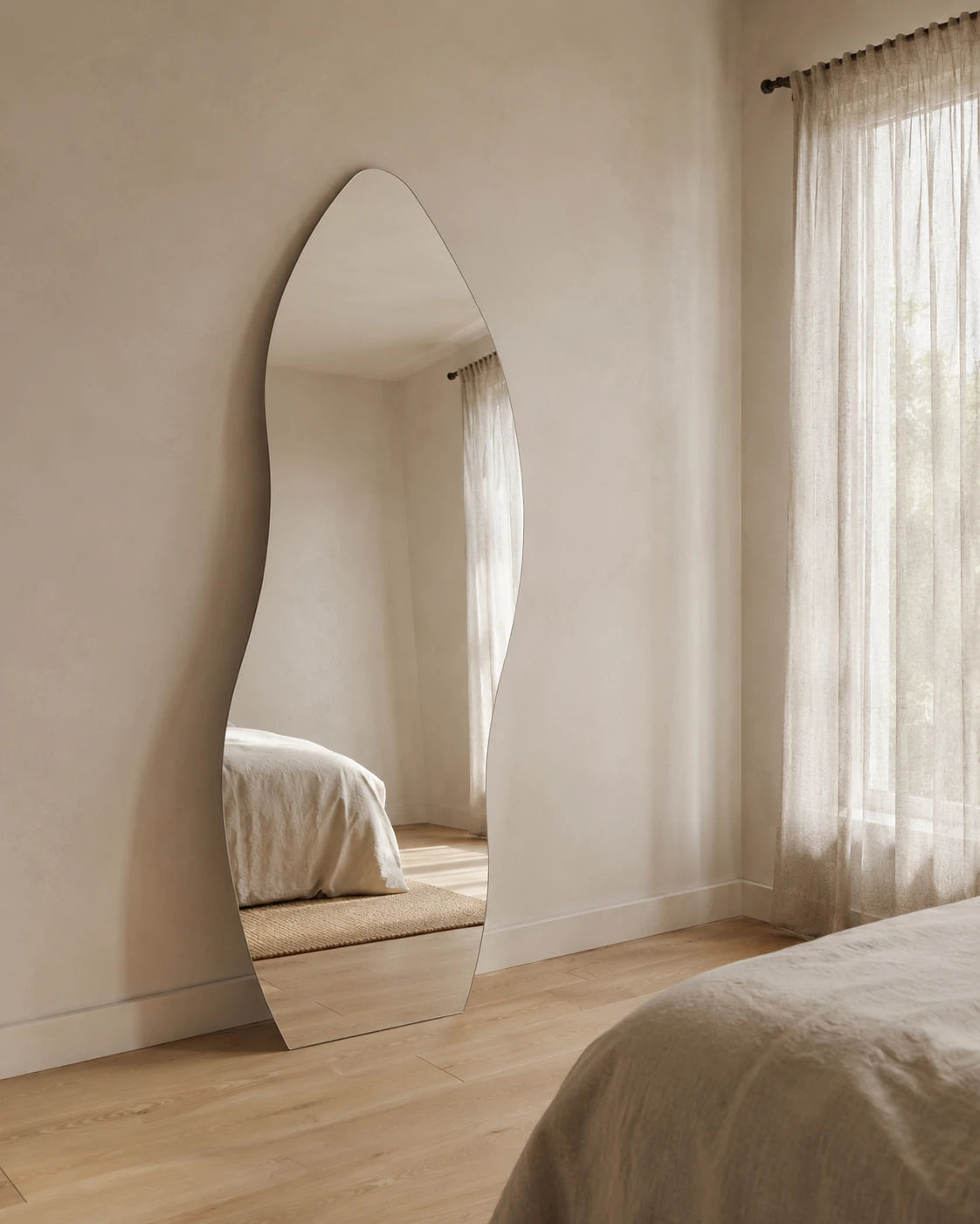 Allira curved full length mirror leaning in a bedroom by sheer curtains