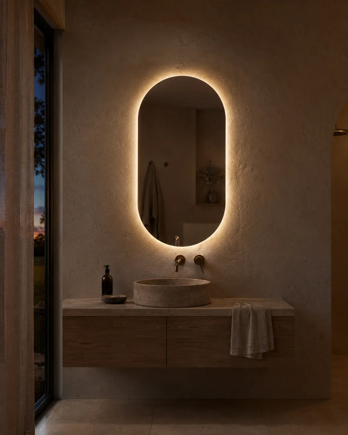 Elena LED wall mirror glowing above a bathroom vanity at dusk