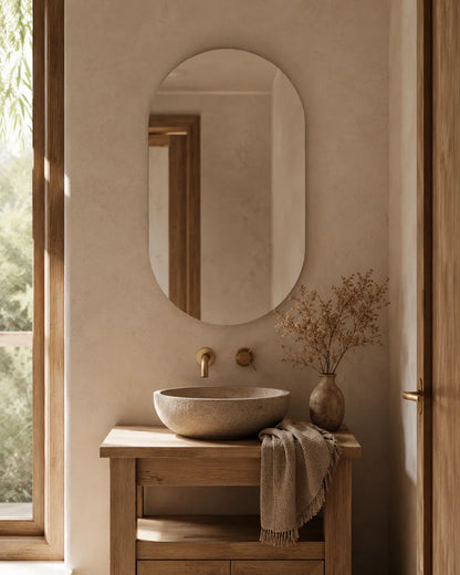 Elena frameless pill wall mirror above a stone basin vanity in a bathroom