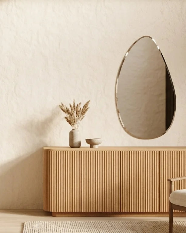 Sofia asymmetric frameless mirror above a fluted timber sideboard in a warm neutral living room