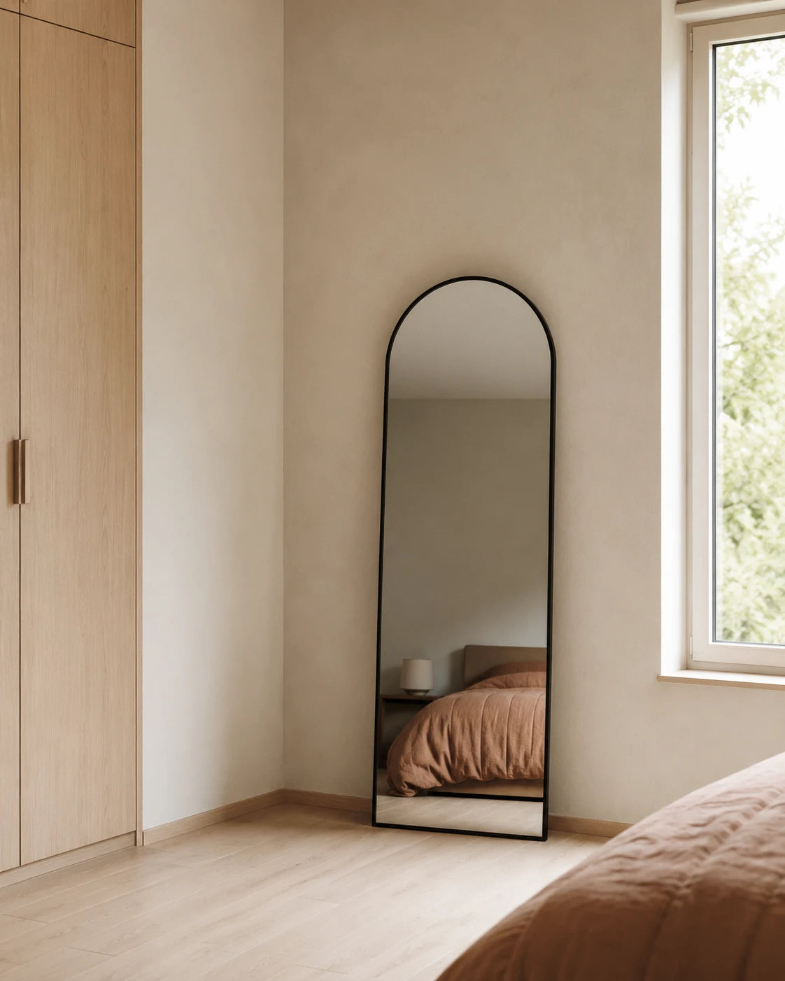 Sienna arch full length mirror leaning in a bedroom corner beside the wardrobe