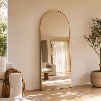 Sienna arch full length mirror 1800 x 850 in Brushed Gold, leaning full-height in a warm living room