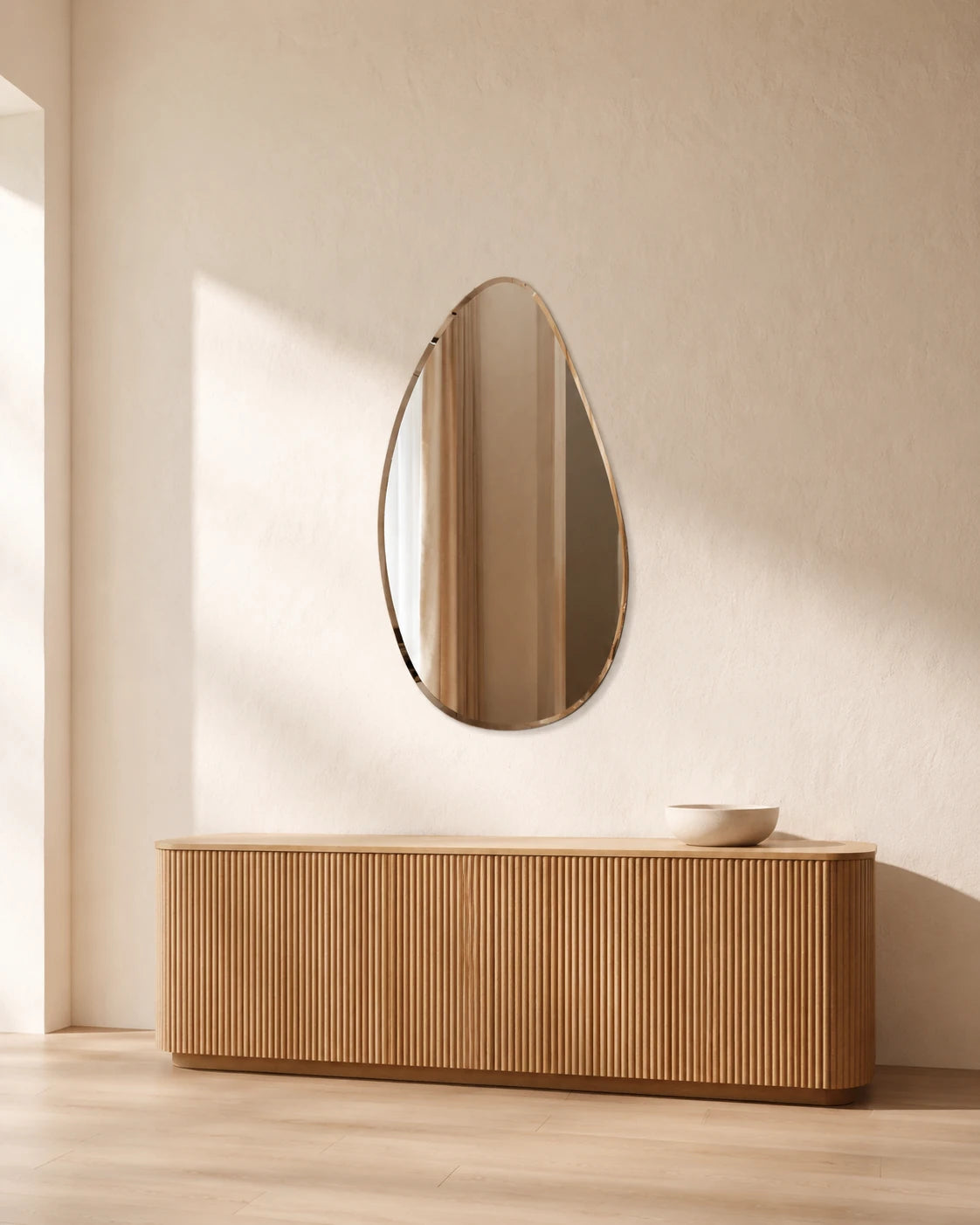 Sofia asymmetric wall mirror above an oak sideboard in a sunlit entry